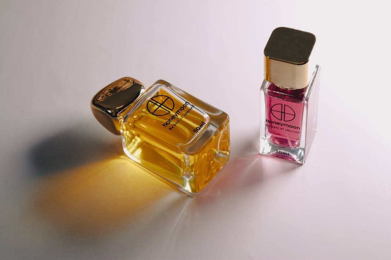 about-02 Close-up of elegant glass perfume bottles on a white surface showcasing luxury scents.