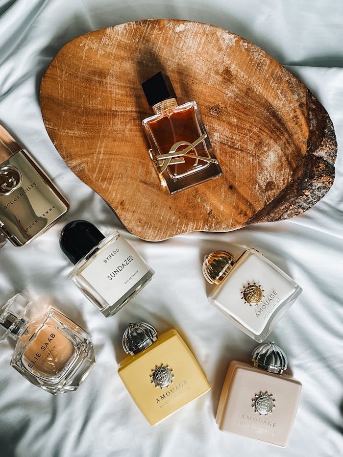 who-we-are Flat lay of luxury perfume bottles on wood and fabric background. Stylish and elegant fragrance display.